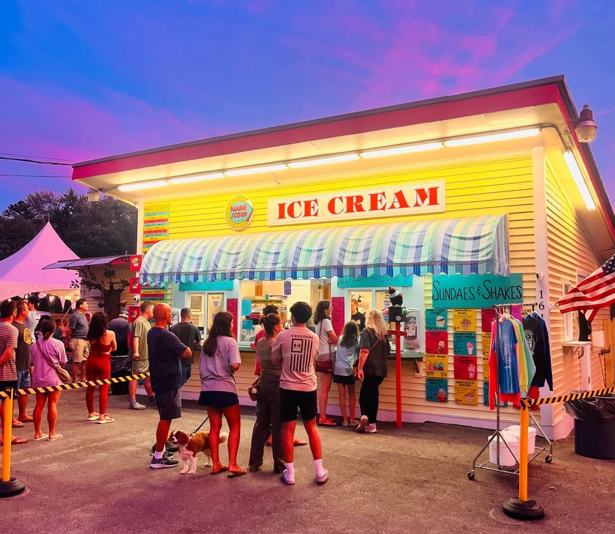 The Maine Scoop Company at dusk, wide shot with parking lot and purple sky