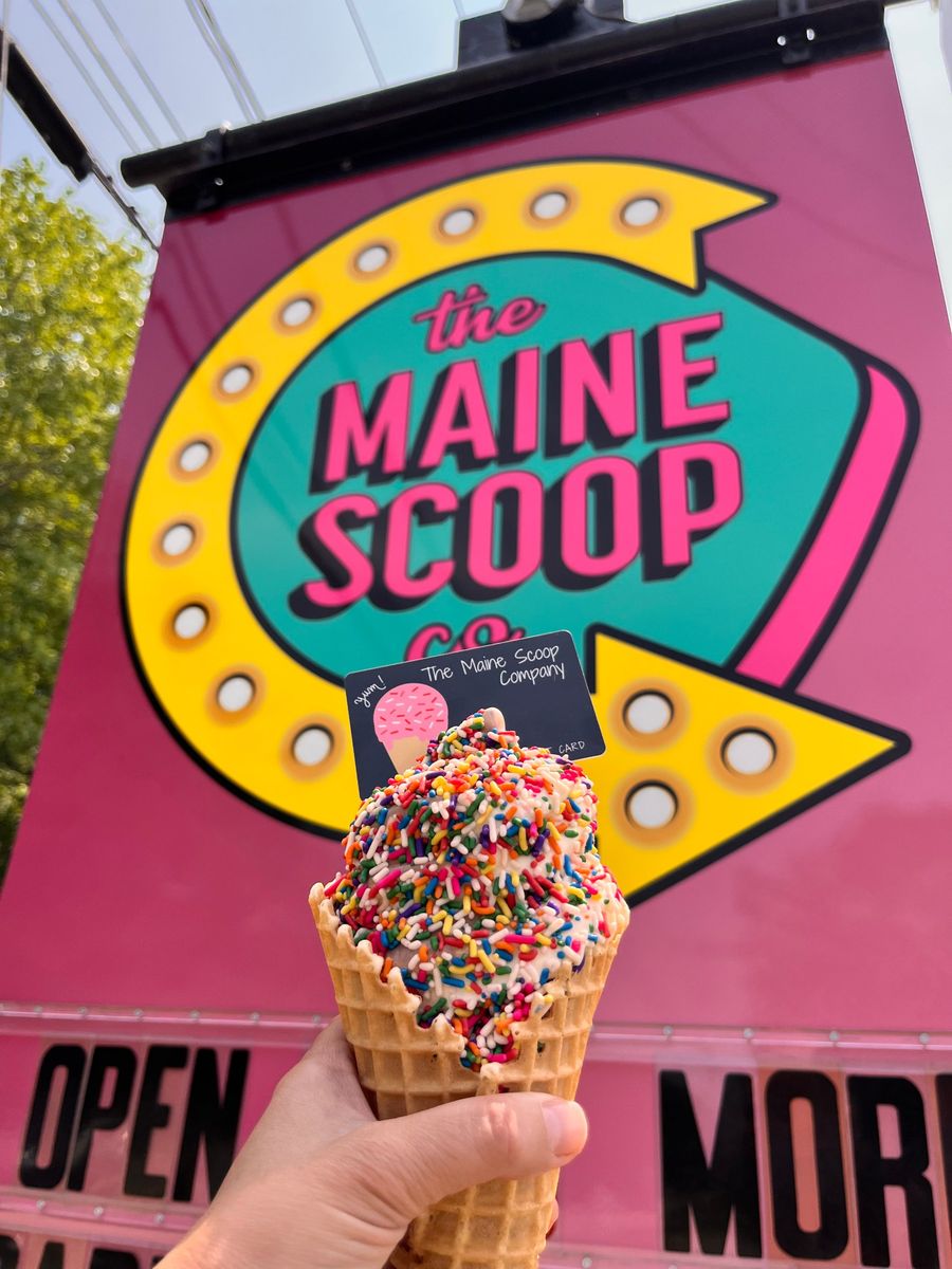 Sprinkle cone in front of The Maine Scoop Company sign